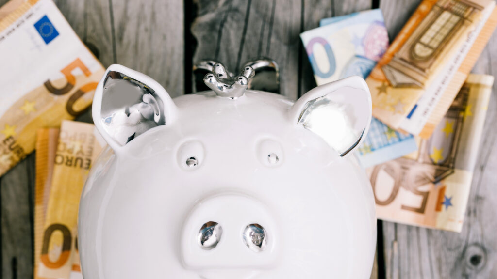 primer plano de la cara del piggybank blanco con billetes en euros